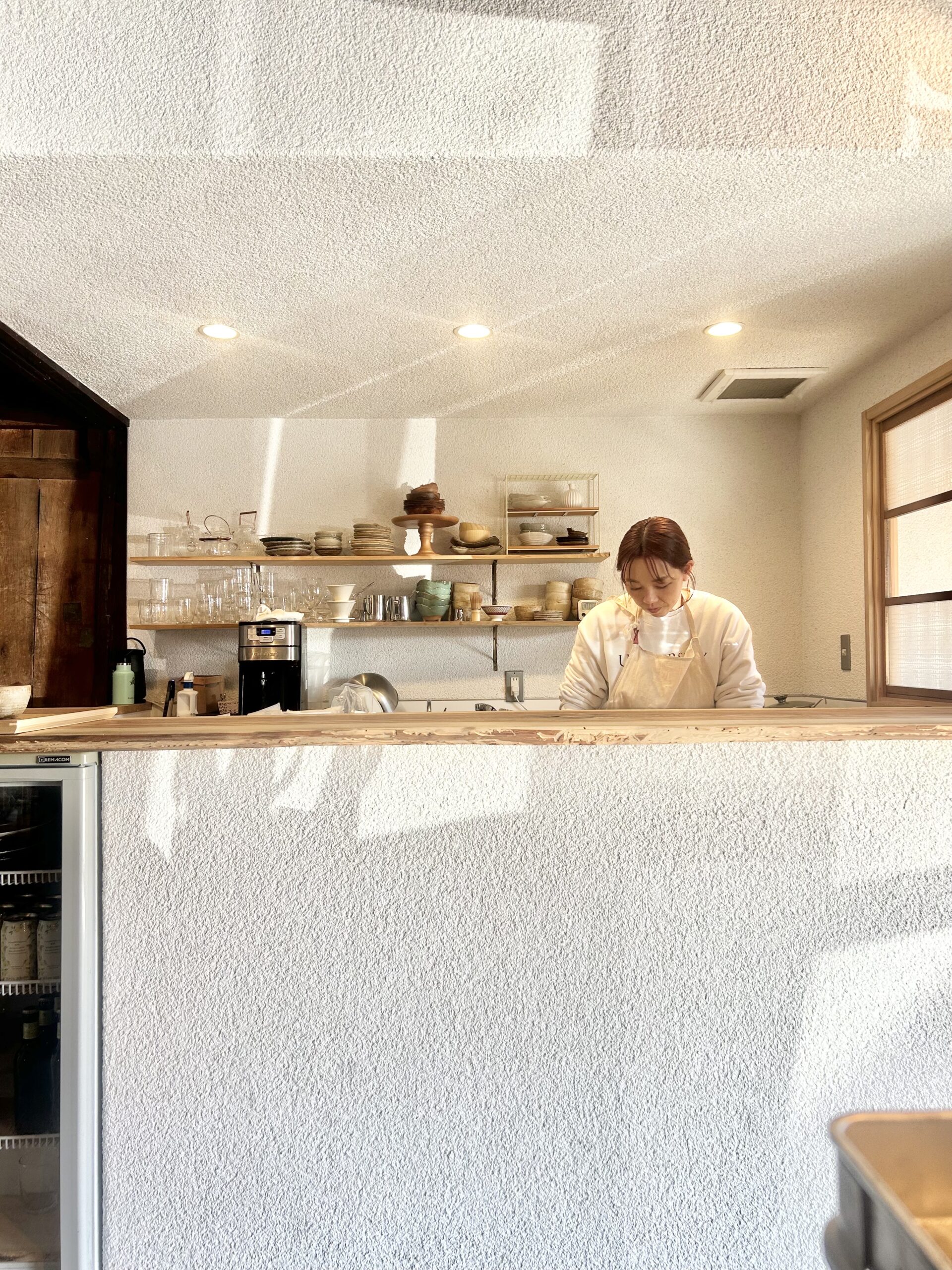 カウンター内で作業するエプロン姿の女性